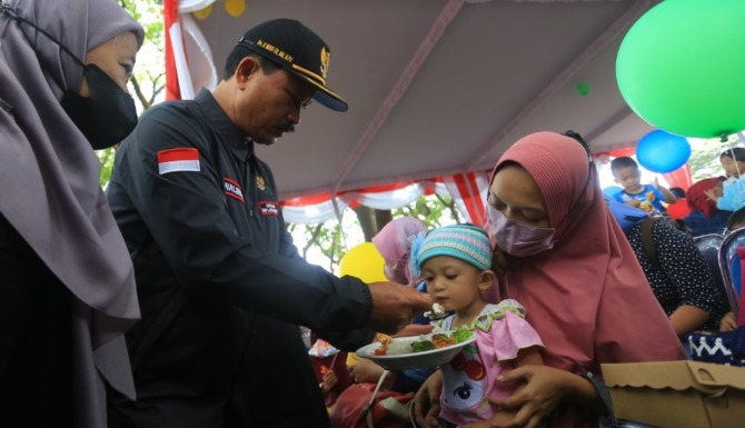 DEMI GENERASI: Wali Kota Madiun Maidi menyuapi anak stunting usai me-launching program Warung Stop Stunting di Ngrowo Bening Edupark kemarin. (BAGAS BIMANTARA/JAWA POS RADAR MADIUN)