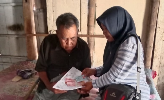 DOOR-TO-DOOR: Penyaluran BLT BBM dari Pemkab Ngawi ke rumah keluarga penerima manfaat yang tidak bisa hadir di kantor desa setempat. (DINSOS NGAWI UNTUK JAWA POS RADAR NGAWI)