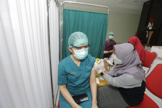 TERUS BERLANJUT: Nakes di Kota Madiun mendapat suntikan vaksin booster kedua beberapa waktu lalu. (BAGAS BIMANTARA/JAWA POS RADAR MADIUN)