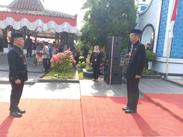 PUNCAK: Bupati Suprawoto menerima laporan penyelenggaran upacara Hari Jadi ke-347 Magetan dari Sekda Hergunadi, Rabu (12/10). (APRILITA SARI/RADAR MAGETAN)