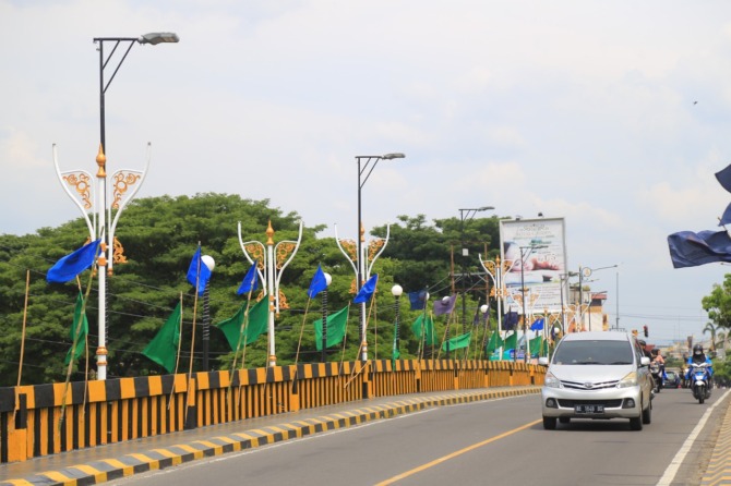 MODEL KLASIK: Disperkim Kota Madiun memasang lampu PJU baru di jembatan Manguharjo, Rabu (23/11). (BAGAS BIMANTARA/JAWA POS RADAR MADIUN)