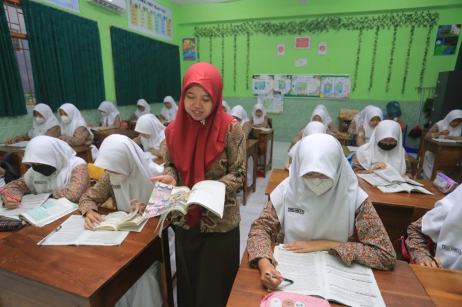 SERIUS: Seorang guru madrasah sedang mengajar di kelas. Kemenag bantah seleksi PPPK telah dibuka. (BAGAS BIMANTARA/JAWA POS RADAR MADIUN)