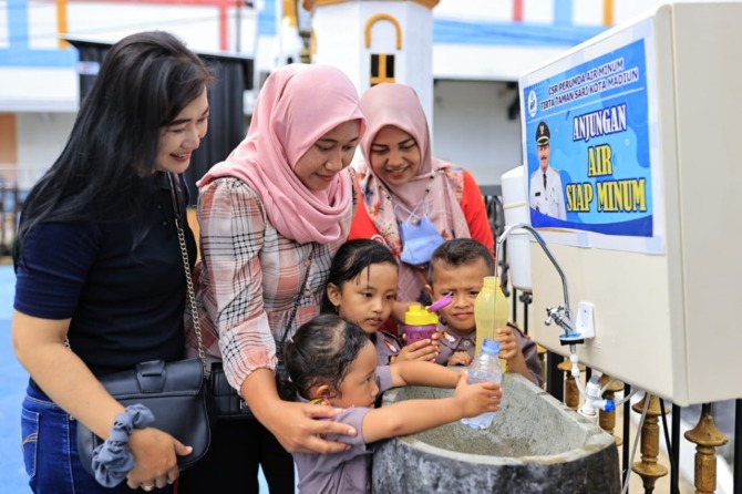 DIJAMIN AMAN: Sejumlah pengunjung memanfaatkan keran air siap minum di kawasan Pahlawan Religi Center kemarin (2/11). (WS HENDRO/DISKOMINFO FOR JAWA POS RADAR MADIUN)