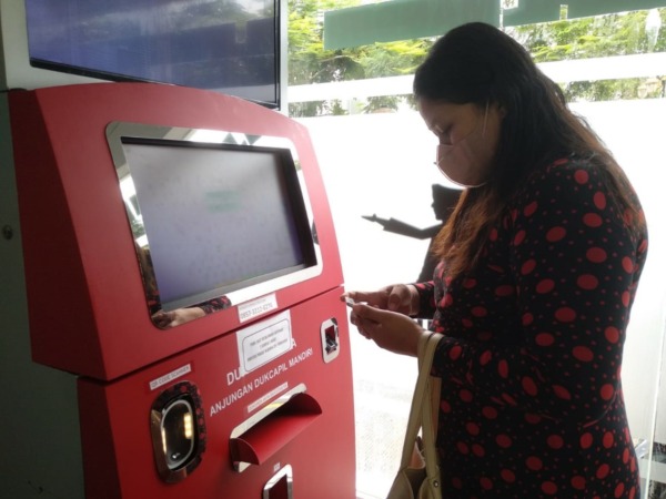 DIGITAL: Seorang warga Kota Madiun sedang menggunakan mesin ADM. (RAHMA DWI LESTARI/JAWA POS RADAR MADIUN)