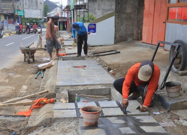 MASIH BERPROGRES: DPUPR mengebut pekerjaan trotoar di sejumlah titik jalan di Kota Madiun. (BAGAS BIMANTARA/JAWA POS RADAR MADIUN)