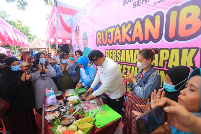 NUTRISI: Wali Kota Maidi didampingi ketua TP PKK Kota Madiun menyiapkan rujak untuk para ibu hamil kemarin. (BAGAS BIMANTARA/JAWA POS RADAR MADIUN)