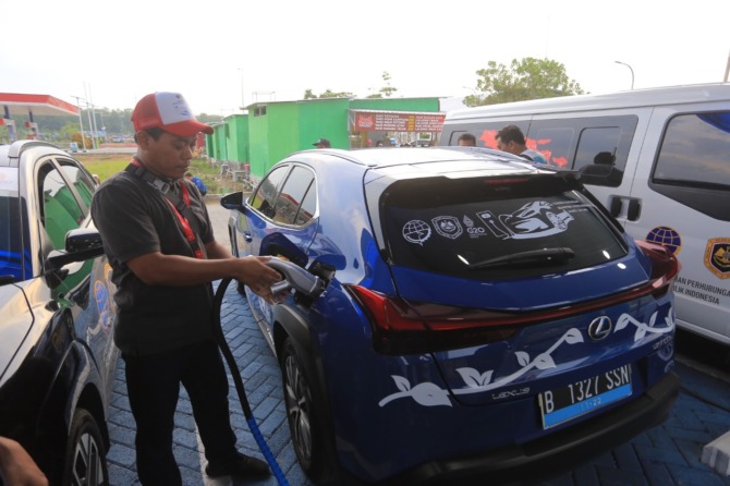 ISI BATERAI: Rombongan touring mobil listrik berhenti di SPKLU Saradan, Kabupaten Madiun, untuk mengisi daya baterai. (BAGAS BIMANTARA/JAWA POS RADAR MADIUN)