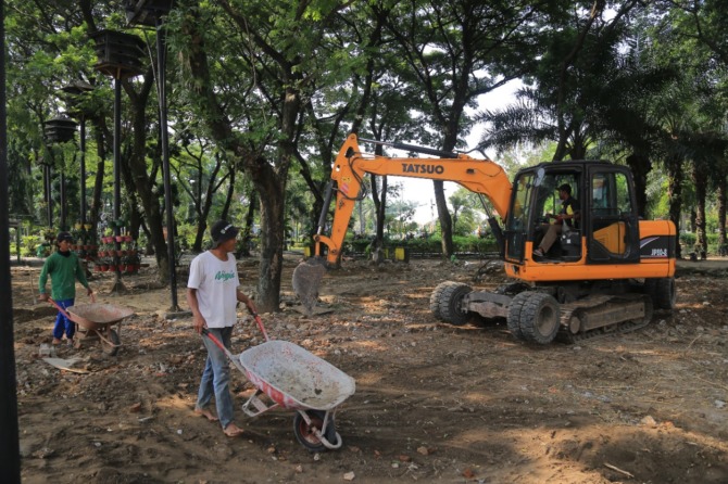 SIAP-SIAP: DPUPR Kota Madiun membongkar pagar alun-alun dan menyiapkannya lahannya untuk area parkir BCC, Senin (12/12). (BAGAS BIMANTARA/JAWA POS RADAR MADIUN)