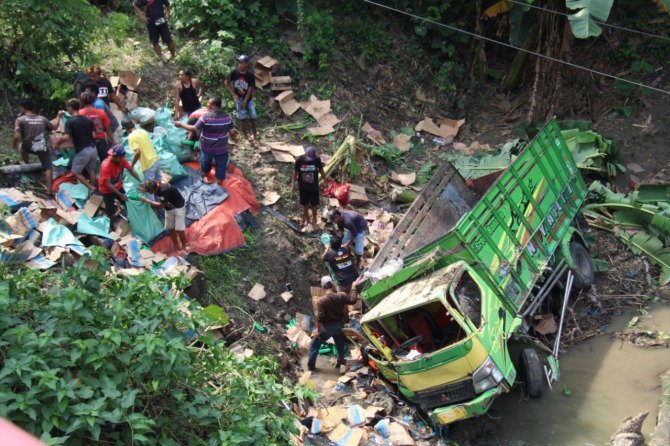 MONCONG MENANCAP: Truk Mitsubishi S 9935 UN bermuatan puluhan kardus oli mesin terjun ke dasar Sungai Bangon di Desa/Kecamatan Karangjati, Minggu, (4/12). (ASEP SYAEFUL BACHRI/JAWA POS RADAR NGAWI)