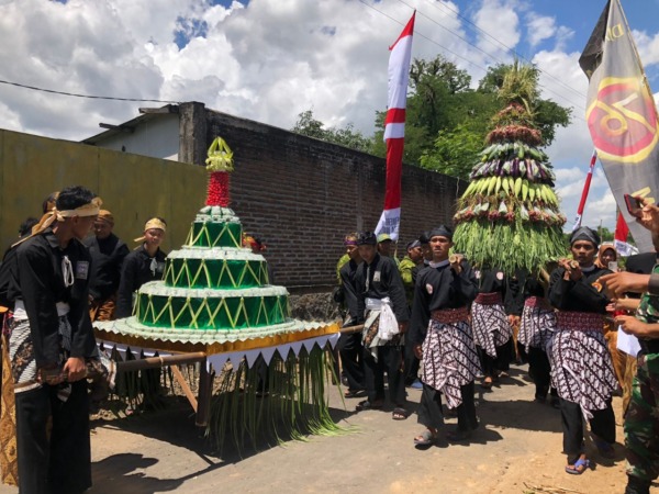 KEARIFAN LOKAL: Gunungan klepon dan hasil bumi diarak keliling Desa Wates, Minggu (18/12). (ESTI RAHAJENG FOR JAWA POS RADAR MAGETAN)