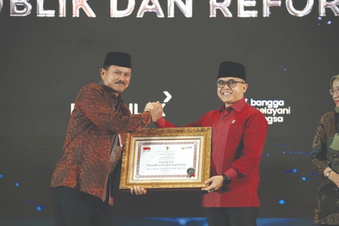 INOVATIF: Wali Kota Madiun Maidi menerima penghargaan dari Menpan RB Abdullah Azwar Anas, Selasa (6/12). (DISKOMINFO KOTA MADIUN FOR JAWA POS RADAR MADIUN)