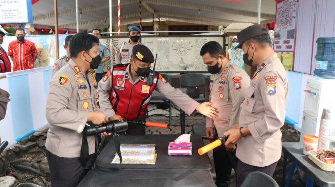 STERILISASI: Polisi memastikan keamanan gereja sehari sebelum perayaan Natal. (POLRES FOR JAWA POS RADAR PONOROGO)
