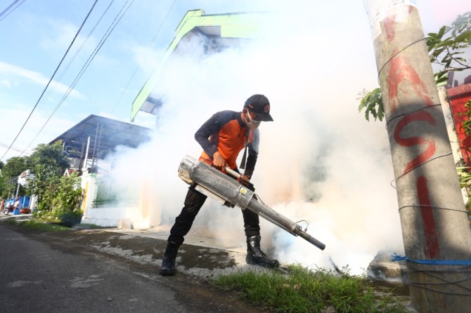 PENGASAPAN: Tim Dinkes PPKB dan BPBD Kota Madiun melakukan fogging di Kelurahan Patihan, Manguharjo, menyusul adanya temuan kasus DBD di wilayah tersebut. (BAGAS BIMANTARA/JAWA POS RADAR MADIUN)