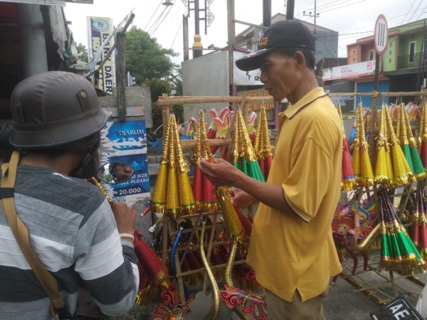 MUSIMAN: Satino yang mangkal di Pasar Srijaya sedang menata dagangannya. (RAHMA DWI LESTARI/JAWA POS RADAR MADIUN)