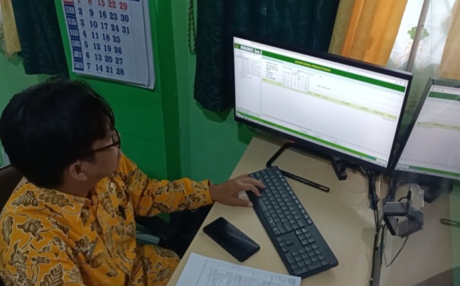 KUOTA TAMU ALLAH: Petugas dari Kemenag Pacitan melakukan pengecekan data calon jamaah yang tercatat dalam sistem informasi dan komputerisasi haji terpadu (Siskohat) kemarin (6/1). (HENGKY RISTANTO/RADAR PACITAN)