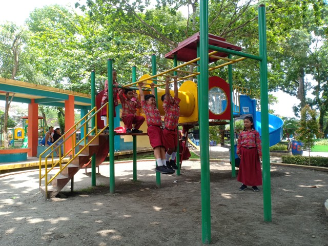 TETAP WASPADA: Siswa didampingi guru asyik bermain di Alun-Alun Magetan saat jam istirahat. (APRILITA SARI/JAWA POS RADAR MAGETAN)