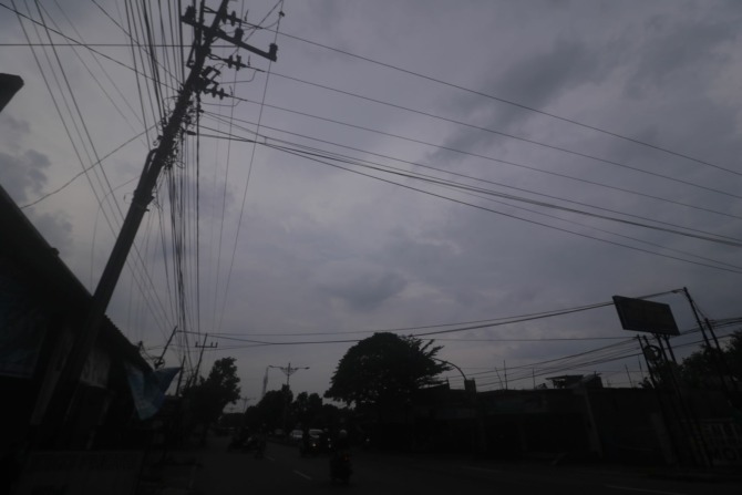 RUSAK PEMANDANGAN: Salah satu kabel FO yang semrawut di wilayah selatan Kabupaten Madiun. Pemkab berencana menerbitkan perda penataan jaringan telekomunikasi pasif. (BAGUS RAHADI/JAWA POS RADAR MADIUN)