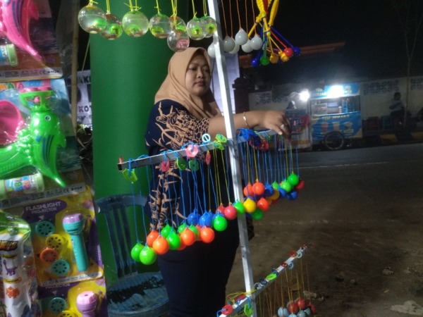BOOMING: Erik Anawati sedang menata latto-latto dagangannya. (RAHMA DWI LESTARI/JAWA POS RADAR MADIUN)