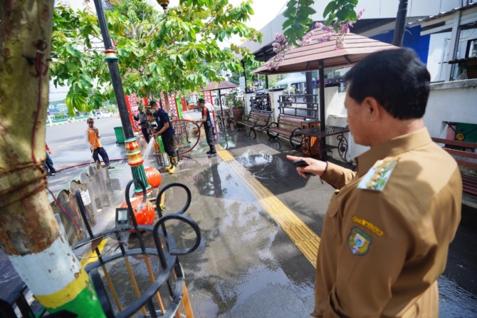 TETAP KINCLONG: Wali Kota Madiun Maidi meninjau bersih-bersih kawasan Pahlawan Street Center seusai perayaan Nataru, Senin (2/1).