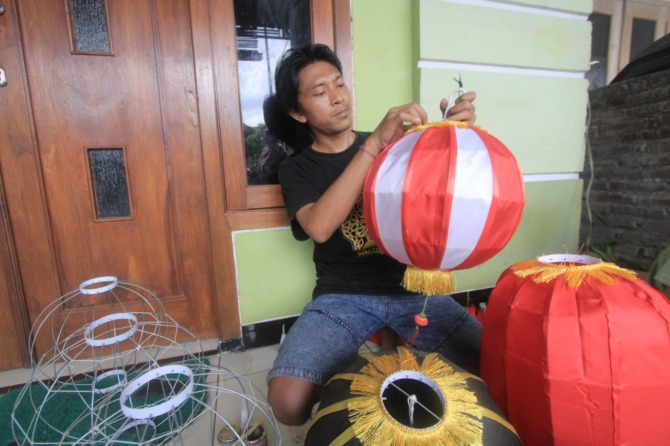 KEWALAHAN: Anton Pratama, perajin lampion asal Kelurahan Surodikraman banjir orderan jelang perayaan tahun baru imlek tahun ini. (AJI PUTRA/JAWA POS RADAR PONOROGO)