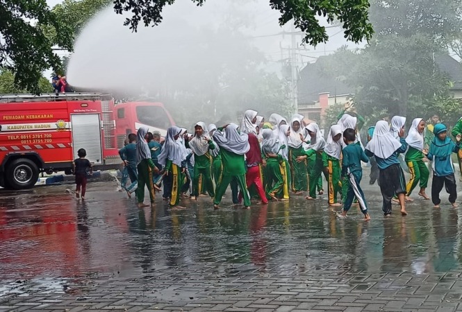 EDUKASI : Ratusan siswa MI Bajulan mengikuti simulasi penanganan kebakaran di basecamp damkar Caruban kemarin. (DIAN RAHAYU/JAWA POS RADAR MADIUN)