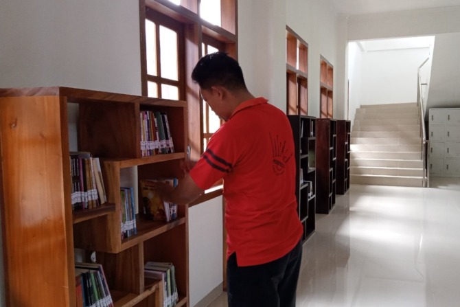 SEPI: Petugas merapikan koleksi bacaan di Graha Pusat Literasi, Selasa (3/1). (NUR CAHYONO/ JAWA POS RADAR MAGETAN)