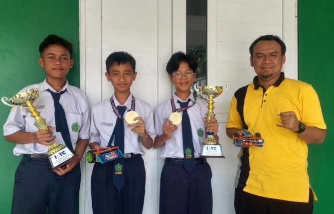 GO INTERNATIONAL: Tim robotika MTsN 3 Madiun dan piala yang berhasil diboyong dari Malaysia. (DIAN RAHAYU/JAWA POS RADAR MADIUN)