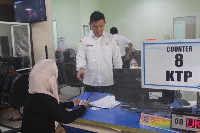 PELAYANAN PUBLIK: Kepala Dispendukcapil Kota Madiun Agus Triono (berdiri) saat meninjau pelayanan registrasi Identitas Kependudukan Digital (IKD).