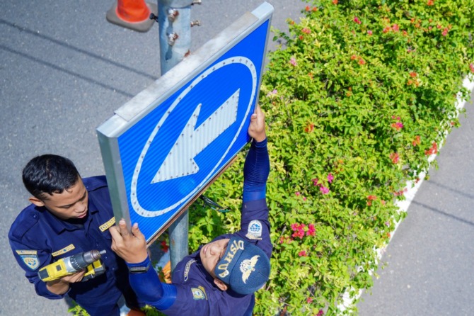 HEMAT ENERGI: Petugas Dishub Kota Maidun memasang rambu lalin bertenaga surya beberapa waktu lalu. (BAGAS BIMANTARA/JAWA POS RADAR MADIUN)