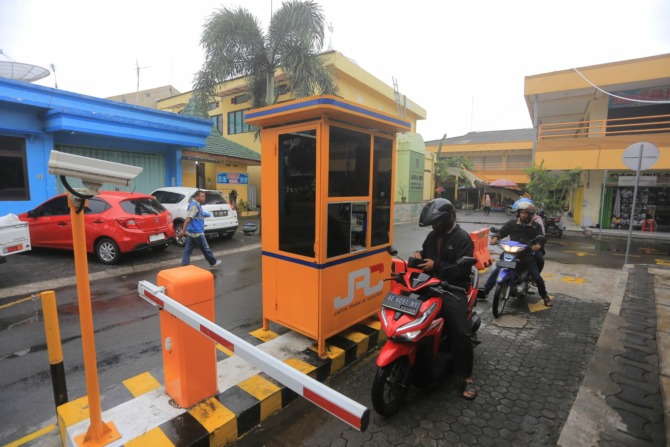 MODERN: Sejumlah warga sedang melintas di gerbang area parkir Pasar Sleko kemarin. (BAGAS BIMANTARA/JAWA POS RADAR MADIUN)