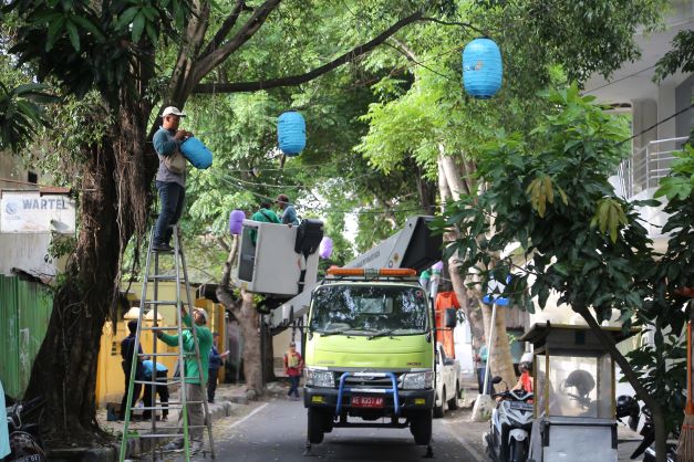 MULAI BERSIAP: Petugas Disperkim Kota Madiun tengah memasang PJU dan pernak-pernik lampion di lokasi Festival Kampung Pecinan kemarin. (BAGAS BIMANTARA/JAWA POS RADAR MADIUN)