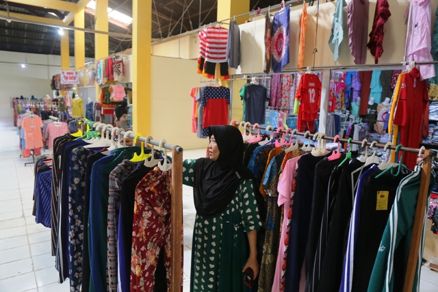 DI-UPGRADE: Salah seorang pedagang konveksi men-display dagangannya di kios lantai 2 Pasar Sleko kemarin (8/2). (BAGAS BIMANTARA/JAWA POS RADAR MADIUN)