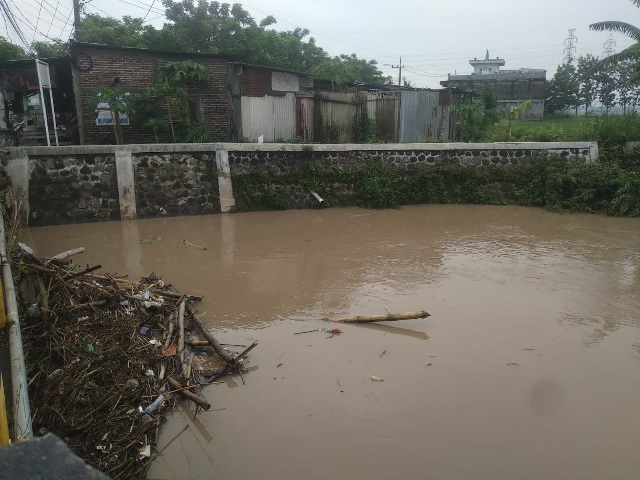USAI MELUAP: Debit air Kali Maling mulai surut dan menyisakan bambrongan yang nyangkut di bawah jembatan Buk Malang kemarin (2/2). (RAHMA DWI LESTARI/JAWA POS RADAR MADIUN)