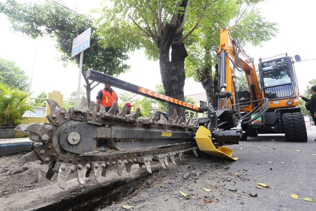 SATU DI INDONESIA: Penggalian aspal dengan alat berat trencher untuk wadah instalasi kabel sistem ducting di Jalan Slamet Riyadi kemarin (16/2). Penggalian bakal berlangsung hingga enam bulan ke depan. (BAGAS BIMANTARA/JAWA POS RADAR MADIUN)