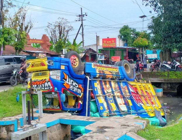 APES: Truk muatan sembilan ton gabah dari Pati, Jawa Tengah, terbalik di sungai kecil, Desa Grabahan, Karangrejo, kemarin. (APRILITA SARI/JAWA POS RADAR MAGETAN)