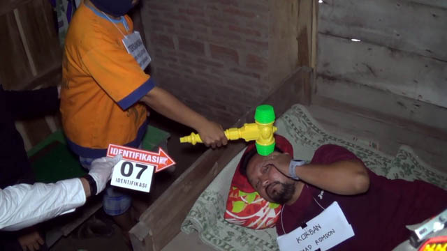 TEGA-TEGANYA: Anis Puji Lestari, 32, memperagakan adegan menghantam kepala suaminya menggunakan palu kayu hingga tewas kemarin. (ASEP SYAEFUL BACHRI/JAWA POS RADAR NGAWI)