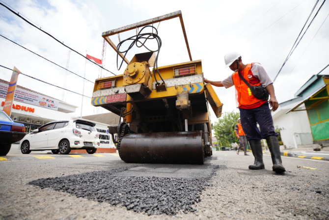 TAMBAL SULAM: DPUPR Kota Madiun berupaya memuluskan sejumlah ruas jalan yang mengalami kerusakan. Tahun ini ada empat proyek pemeliharaan jalan. (BAGAS BIMANTARA/JAWA POS RADAR MADIUN)