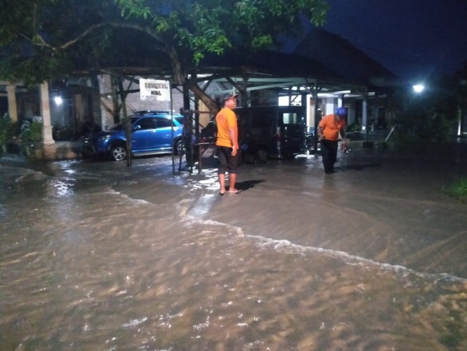 TERGENANG: Sejumlah petugas BPBD saat di lokasi banjir masuk Desa Tempursari, Wungu, kemarin. (BPBD FOR RADAR CARUBAN)