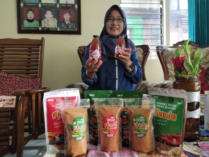 ULET: Sulistyaningsih menunjukkan sirup markisa dan sambal pecel hasil olahannya. (RAHMA DWI LESTARI/JAWA POS RADAR MADIUN)