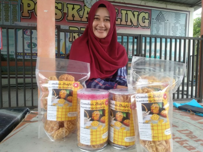 TRADISIONAL: Fitri Wulandari menunjukkan kembang goyang buatannya yang telah dikemas kekinian. (RAHMA DWI LESTARI/JAWA POS RADAR MADIUN)