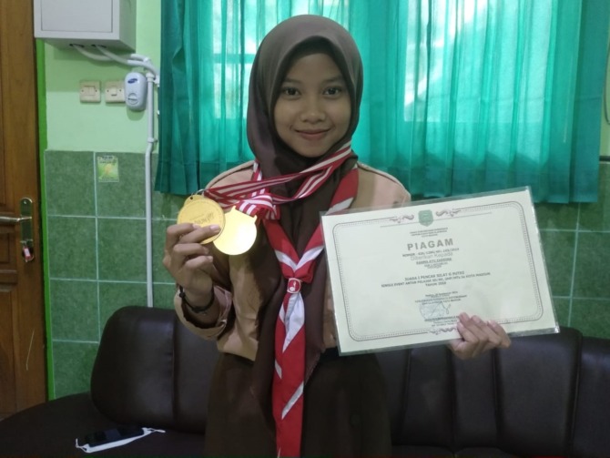 BERPRESTASI: Rahma Ayu Zabina menunjukkan medali dan piagam koleksinya. (RAHMA DWI LESTARI/JAWA POS RADAR MADIUN)