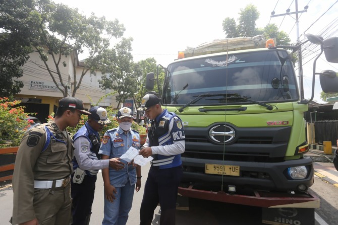 RAZIA KESTIB: Petugas gabungan dishub dan TNI-Polri memeriksa kendaraan angkuran barang di simpang lima Te’an kemarin (22/2). Sasaran utama  kendaraan yang over dimension over loading. (BAGAS BIMANTARA/JAWA POS RADAR MADIUN)