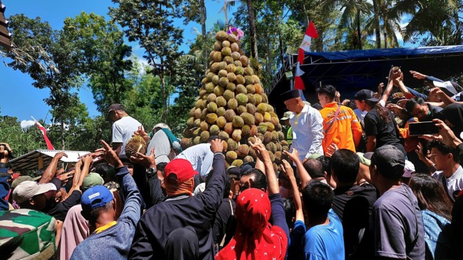 UNIK: Usai doa bersama, ratusan durian dibagikan cuma-cuma kepada pengunjung. (BAGUS RAHADI/JAWA POS RADAR CARUBAN)