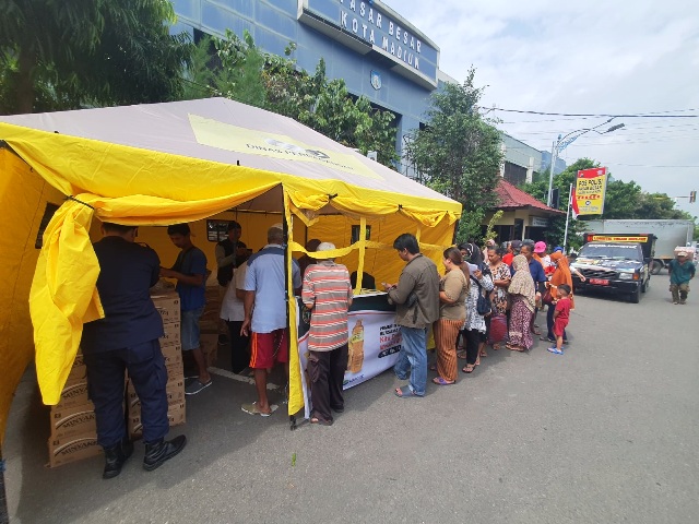 ANTRE: Warga saat mengantre membeli Minyakita dalam operasi pasar di depan PBM. (DISDAG FOR JAWA POS RADAR MADIUN)