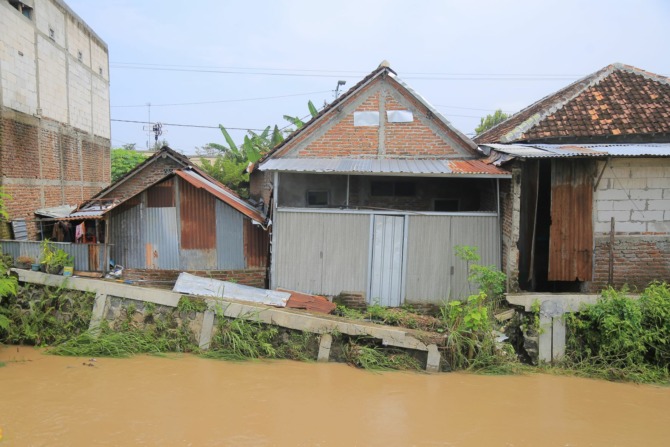 LANGGANAN BANJIR: Hujan deras mengakibatkan Kali Piring meluap menggenangi permukiman di Kelun, Kartoharjo, Rabu (22/3). Kondisi diperparah dengan plengsengan sungai tersebut yang ambrol sejak beberapa waktu lalu dan hingga kini belum tertangani. (BAGAS B
