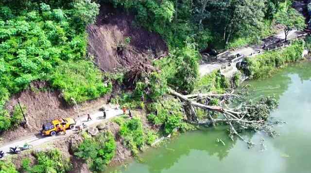 FOTO UDARA: Akses di selingkar Telaga Ngebel terdampak longsor. Petugas gabungan melakukan pembersihan  dengan menyemprotkan air. (BPBD Ponorogo for JAWA POS RADAR PONOROGO)