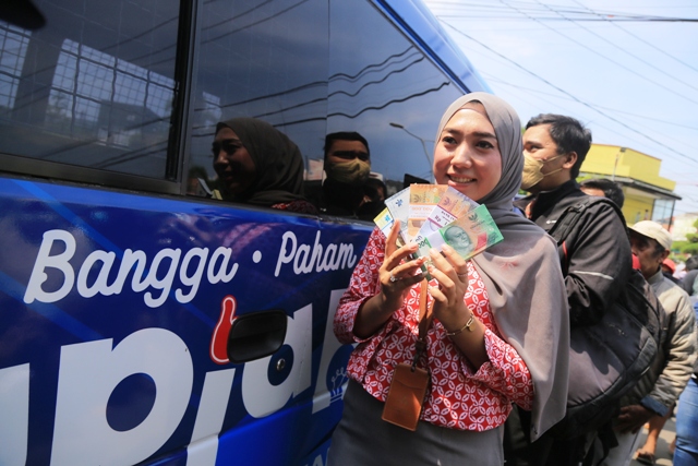 DIBURU: Warga saat antre menukar pecahan uang baru di mobil kas BI yang mangkal di depan Alun-alun Kota Madiun kemarin. (BAGAS BIMANTARA/JAWA POS RADAR MADIUN)