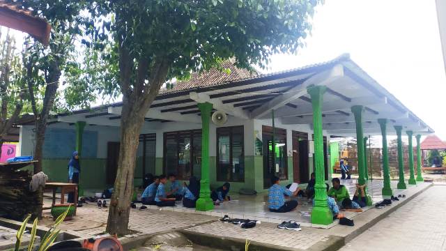DISOAL DEWAN: Sejumlah siswa SMPN 1 Barat berada di masjid sekolah yang rencana perbaikannya disebut batal. (NUR CAHYONO/JAWA POS RADAR MAGETAN)