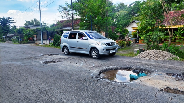 BERLUBANG: Kondisi jalan di Bongsoputro, Saradan, yang rusak berat kemarin (10/3). Pemkab Madiun hanya mampu menangani dua persen jalan setiap tahun. (DIAN RAHAYU/JAWA POS RADAR CARUBAN)