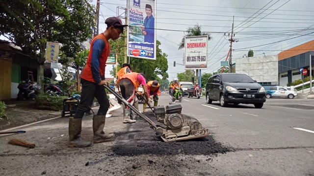 TOTAL 60 KILOMETER: Petugas menambal jalan berlubang agar nantinya tidak menghambat kelancaran arus mudik. (NUR CAHYONO/JAWA POS RADAR MAGETAN)